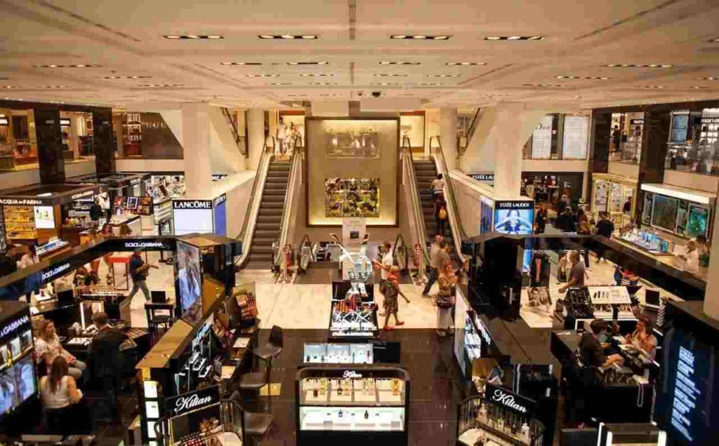 a busy cosmetics mall full of men and women buying make-up