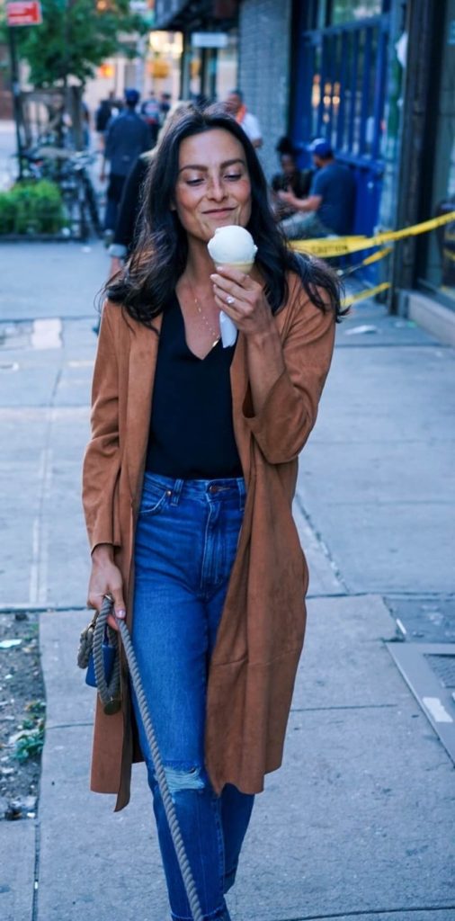 woman wea jeans eating ice cream walking on the street