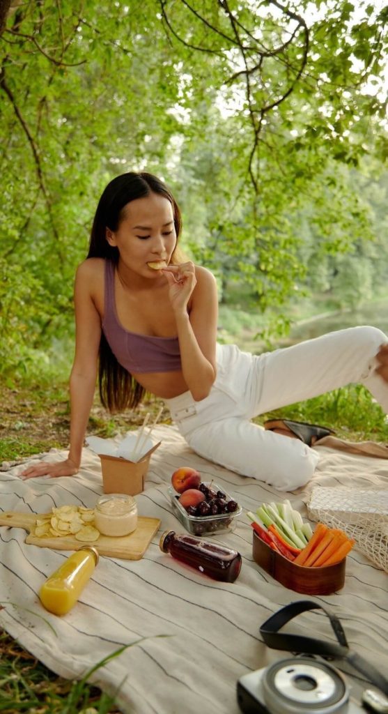woman on the grass eating low calorie fruit best for a diet