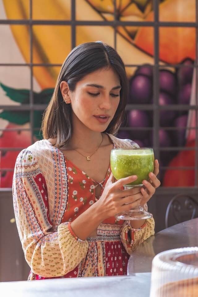 girl drinking a green juice in the mall