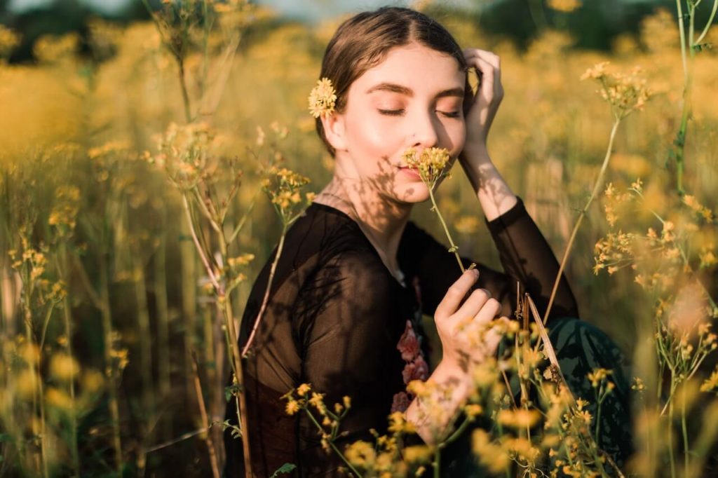 woman smelling a fragrance flower in a field