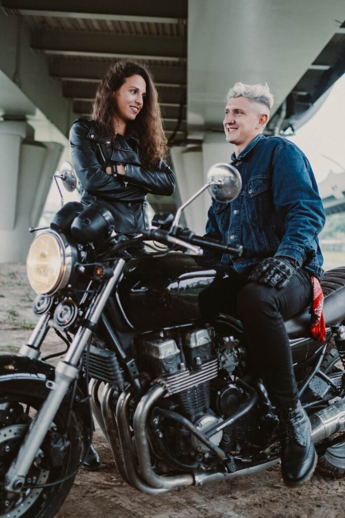 two people wearing leather on a motorcycle 
