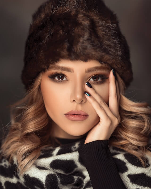 a leopard dress, fur hat and black nails