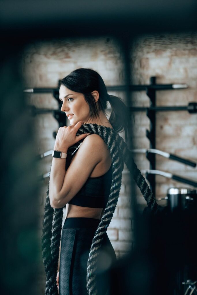woman in black working out at the gym with ropes