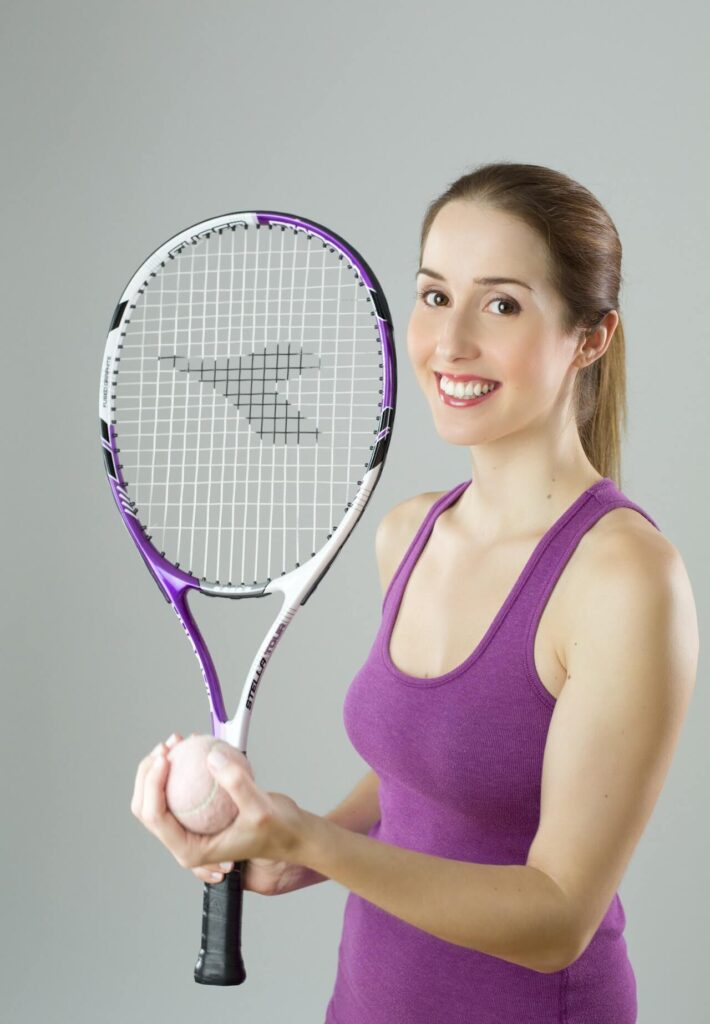 girl with a purple top playing tennis